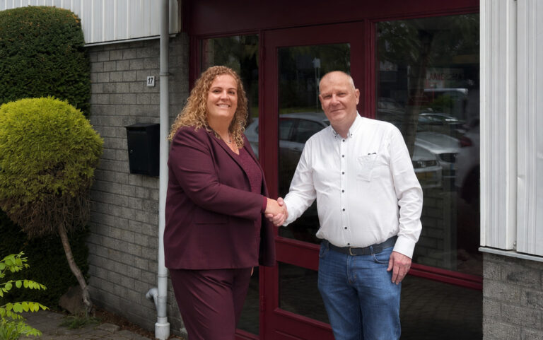 Bert van der Heijden en Suzanne Smak Gregoor-Lammers schudden elkaar de hand na de overname van G.B.I. Transport.